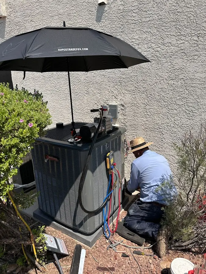 HVAC technician performing outdoor AC maintenance in Hartford City