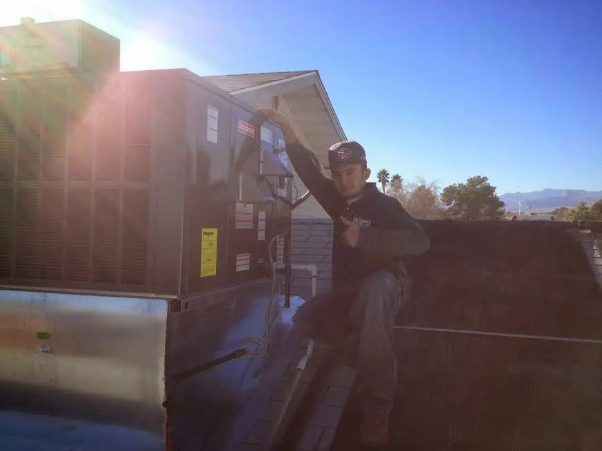 HVAC technician performing Heat Pump Repair on a rooftop unit in Hartford City